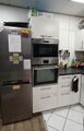 Küche, Blick auf den Kühlschrank und Backofen-/Mikrowellenschrank